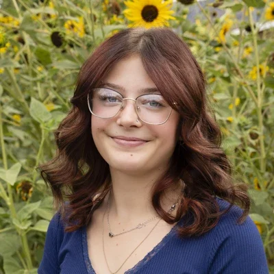 Chiropractic American Fork UT Kailey Meet The Team Platinum Chiropractic team member, Kailey, smiling in sunflower field.