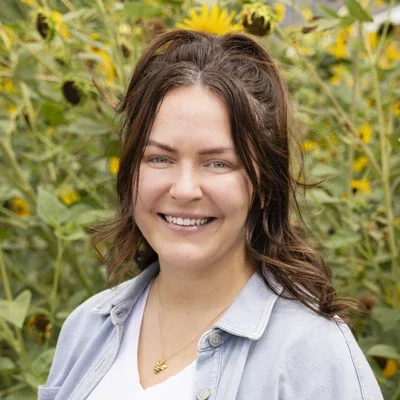 Chiropractic American Fork UT Sierra Meet The Team Platinum Chiropractic team member, Sierra, smiling in sunflower field.