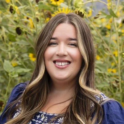 Chiropractor American Fork UT Kelly Rojas Meet The Team New Platinum Chiropractic Chiropractor, Kelly Rojas, smiling in sunflower field.